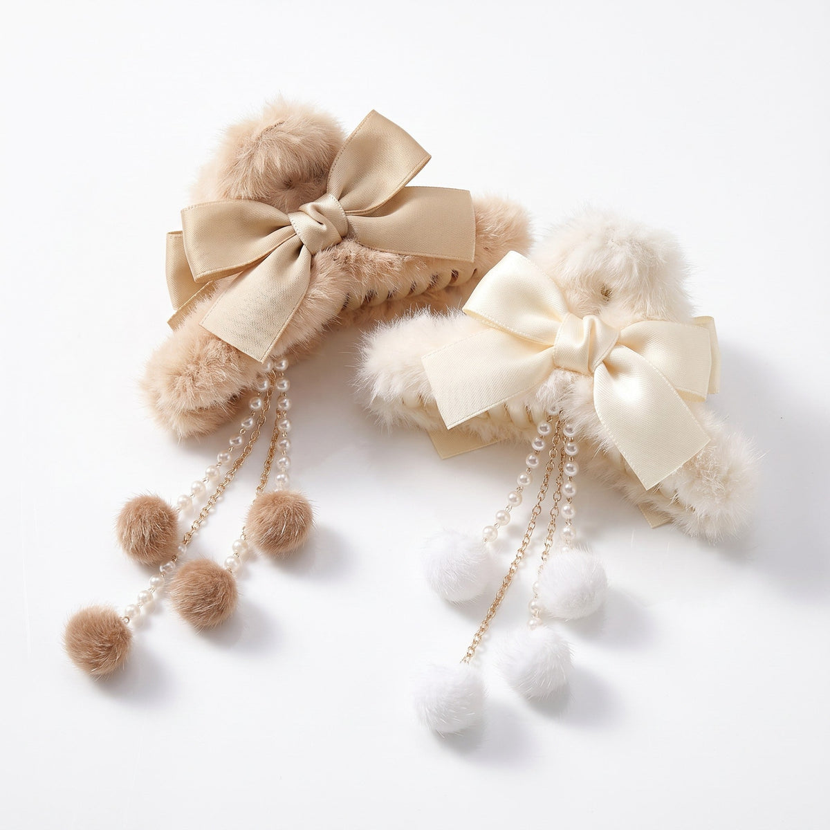 Two faux fur bow hair claw clips with pearl dangle tassels in cream and beige